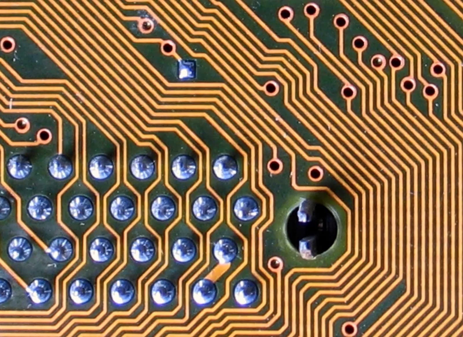 Copper traces winding across a printed circuit board, close up